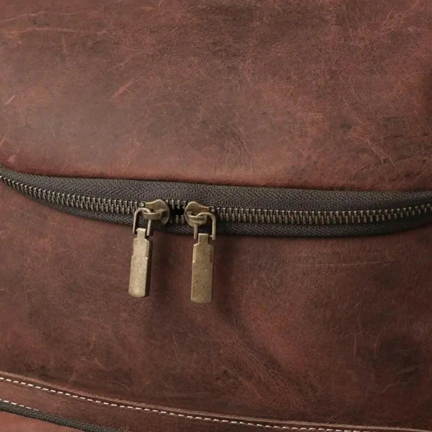 Close-up of a brown leather bag with a zipper