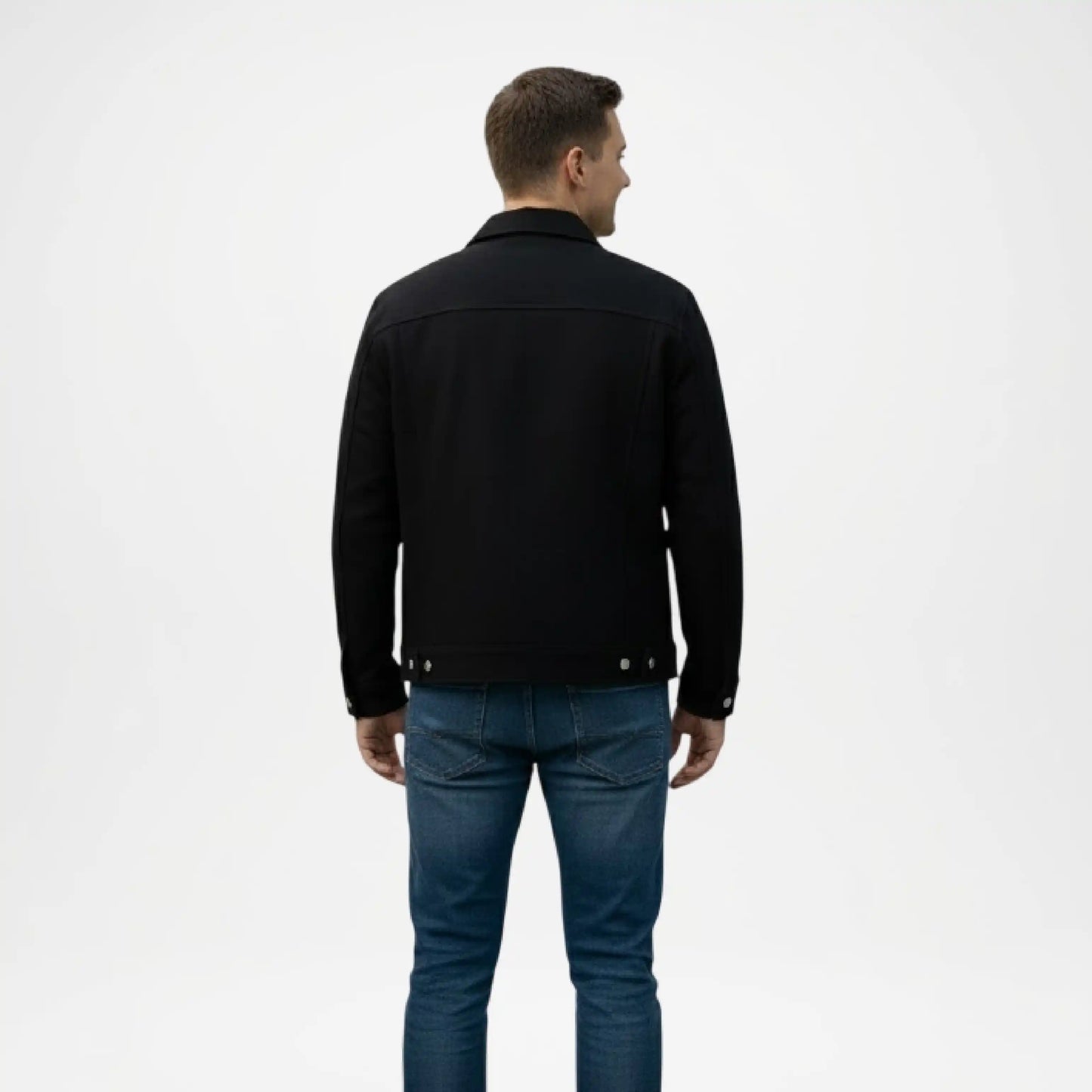 Man wearing a black jacket and blue jeans on a white background