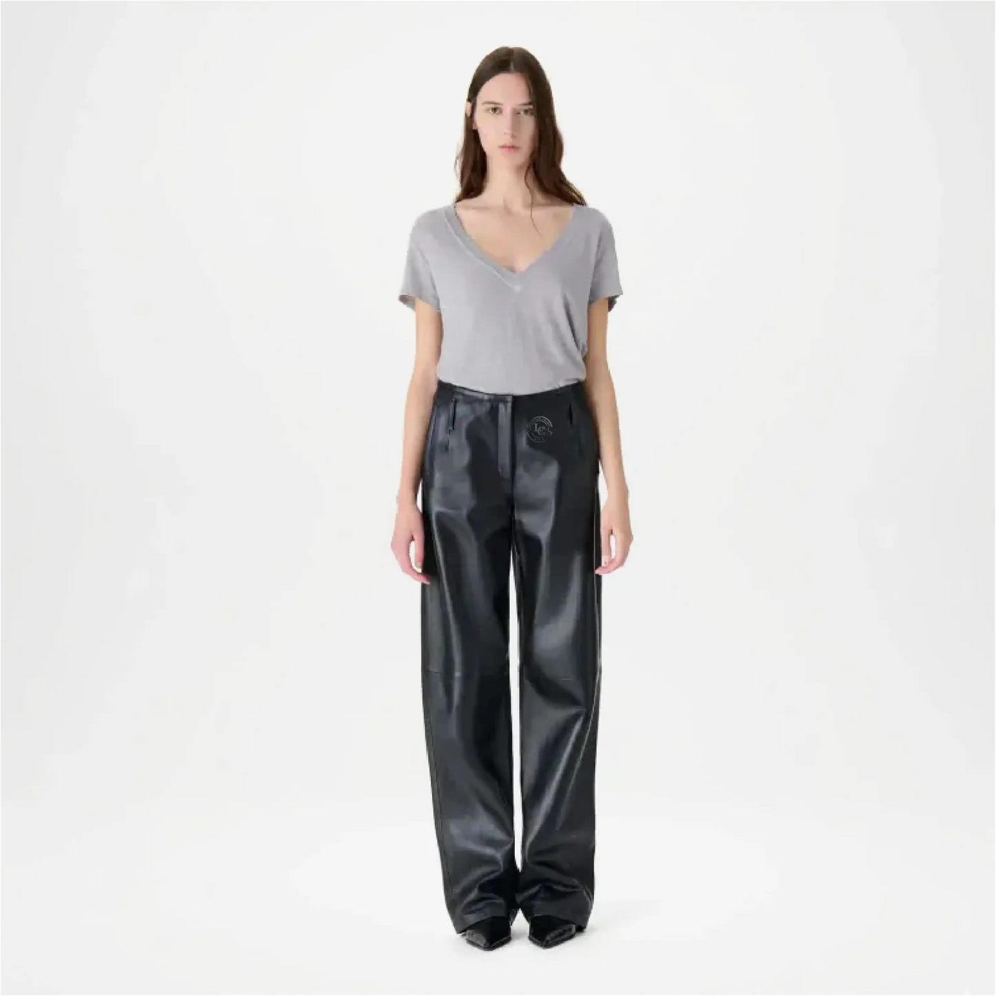 Woman wearing a gray top and black pants on a white background
