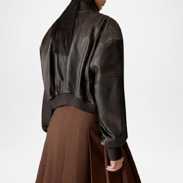 Person wearing a dark brown leather jacket and brown skirt