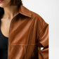 Brown leather jacket worn by a person on a white background