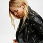 Black leather jacket with star studs worn by a person
