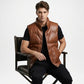 Man wearing a brown leather vest sitting on a chair against a white background