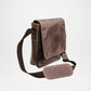 Brown leather crossbody bag on a light gray background