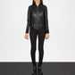 Person wearing a black leather jacket and pants on a white background
