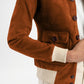 Brown corduroy jacket with white cuffs and buttons