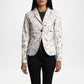 Person wearing a white patterned blazer over black pants