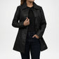 Person wearing a black coat on a white background
