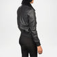 Person wearing a black leather jacket with fur collar