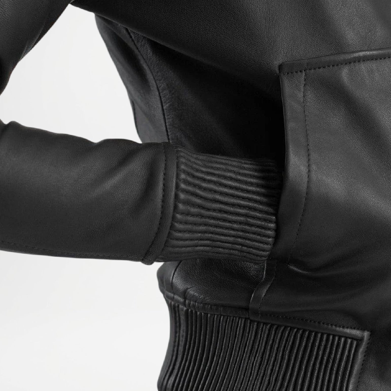 Close-up of a black leather jacket with textured cuffs and waistband