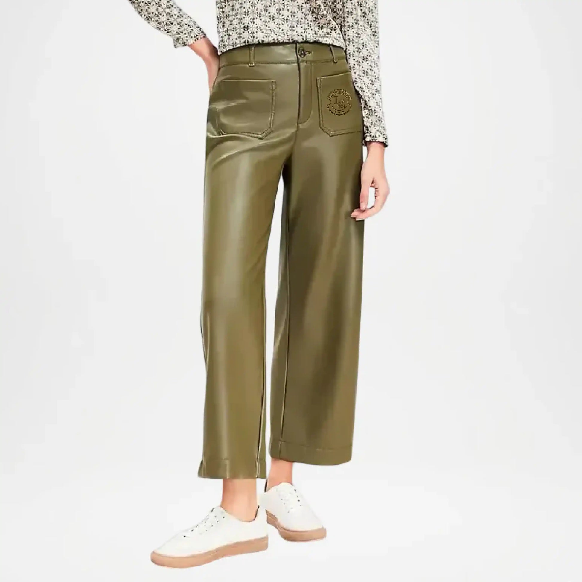 Person wearing olive green leather pants on a white background
