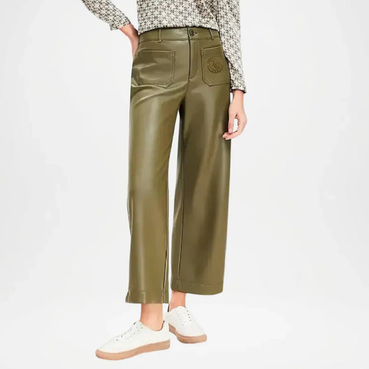 Person wearing olive green leather pants on a white background
