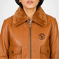 Brown leather jacket with fur collar and logo on a white background close up