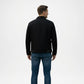 Man wearing a black jacket and blue jeans on a white background