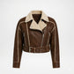 A brown faux-leather aviator-style jacket with a beige sherpa lining, featuring a belted waist, zippered front, and silver-tone hardware on a light gray background.