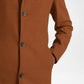 Close-up of a brown coat with button details on a white background