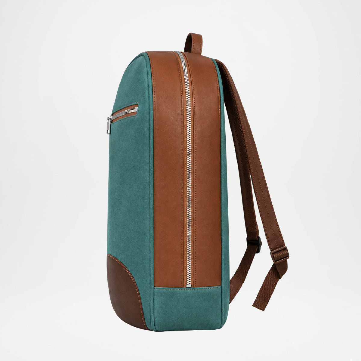 A color-blocked backpack shown from the side profile on a light gray background. The backpack features a teal green canvas body, brown faux-leather panels, and a silver zipper.