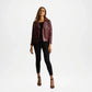Woman wearing a burgundy leather jacket and black pants on a white background