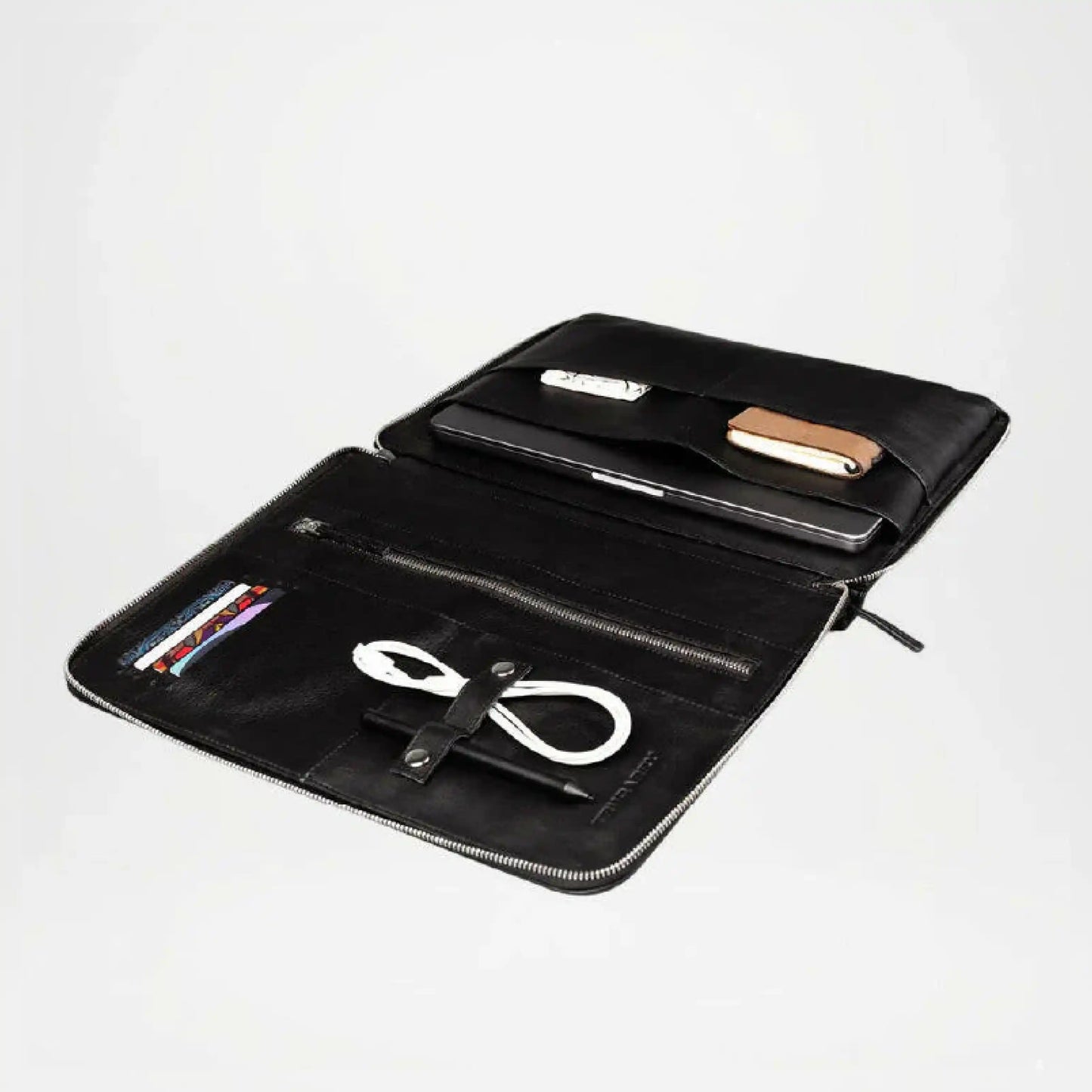 Black leather pouch with compartments holding electronic devices on a white background