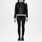 Black leather jacket with white fur lining worn by a person on a white background