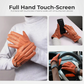Orange touchscreen gloves being worn and used with a smartphone and car steering wheel.
