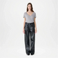 Woman wearing a gray top and black pants on a white background