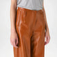 Person wearing brown leather pants close up