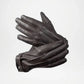 Pair of black leather gloves on a light gray background