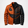 A men's split-color leather jacket with one side in warm cognac brown and the other in black, featuring a large orange stitched jack-o'-lantern face design across the front.