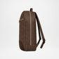 A dark brown faux-leather backpack shown from the side profile against a clean white background.