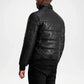 Person wearing a black quilted leather jacket on a white background
