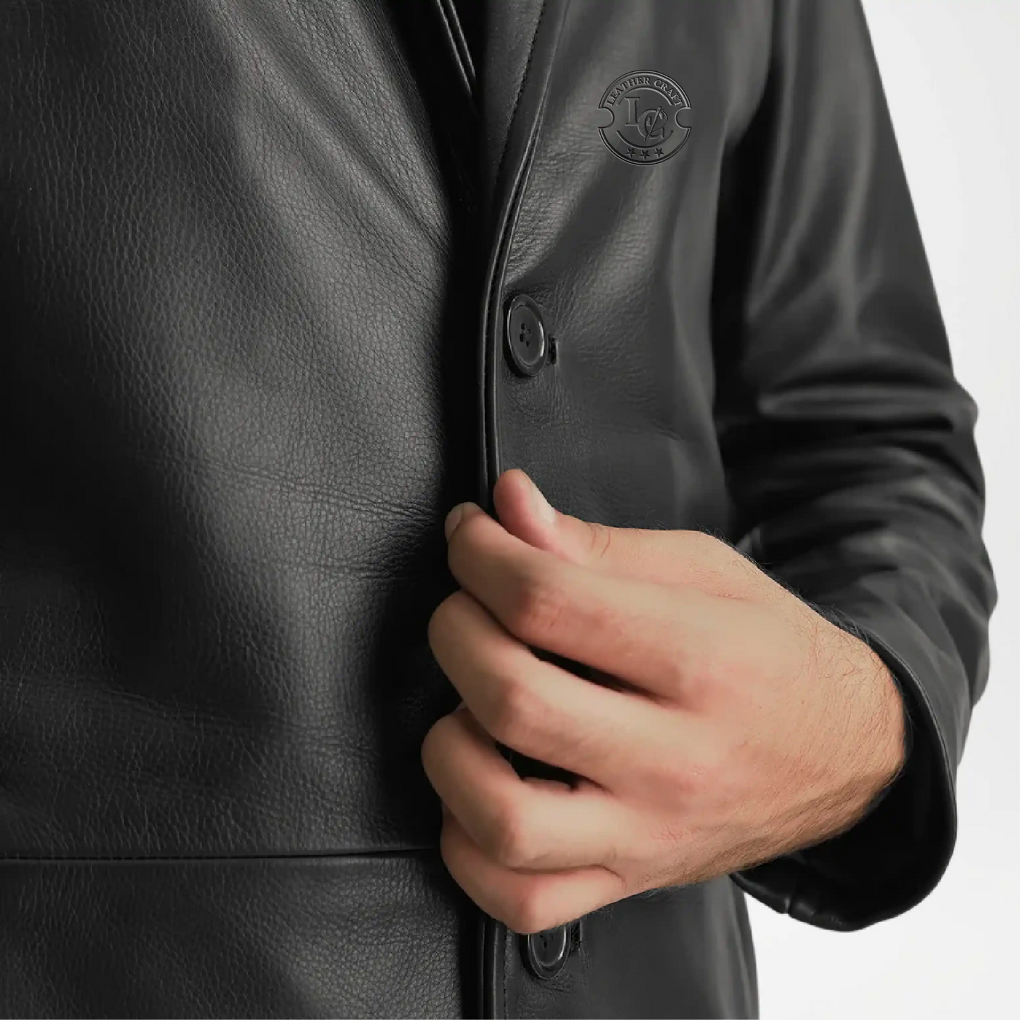 Close-up of a person wearing a black leather coat with a hand adjusting the collar.