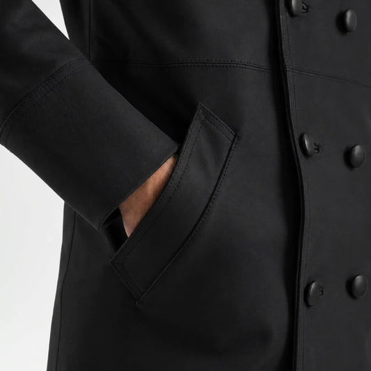Close-up of a black coat with buttons and a pocket on a white background