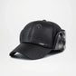 Black leather cap with fur trim on a light gray background