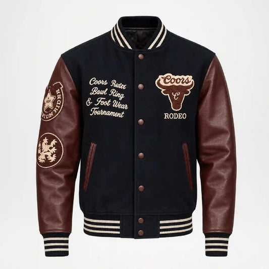 A varsity-style leather jacket with dark navy body panels and brown leather sleeves, featuring embroidered Coors branding and text on the chest and sleeves, shown on a light gray background.