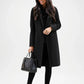Woman wearing a black coat holding a black handbag 