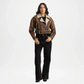 Person wearing a brown shearling jacket and black pants on a white background