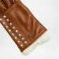 Brown leather glove with studs and white fur lining Close up