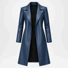 A women's long navy blue faux-leather coat with an asymmetrical lapel and silver snap buttons, displayed on a light gray background.